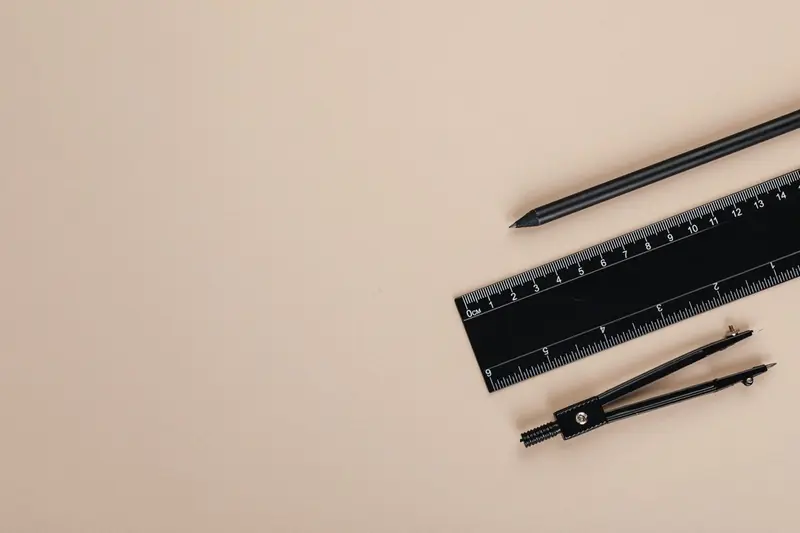 Compass, pencil and ruler on a cream background